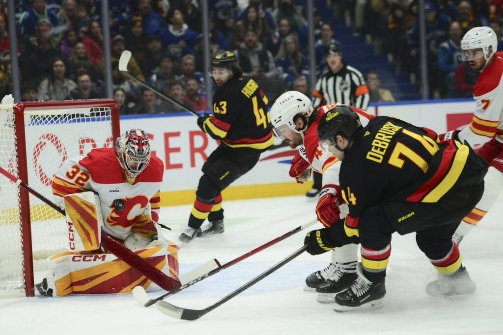 Flames score 5 consecutive goals to surge past Canucks