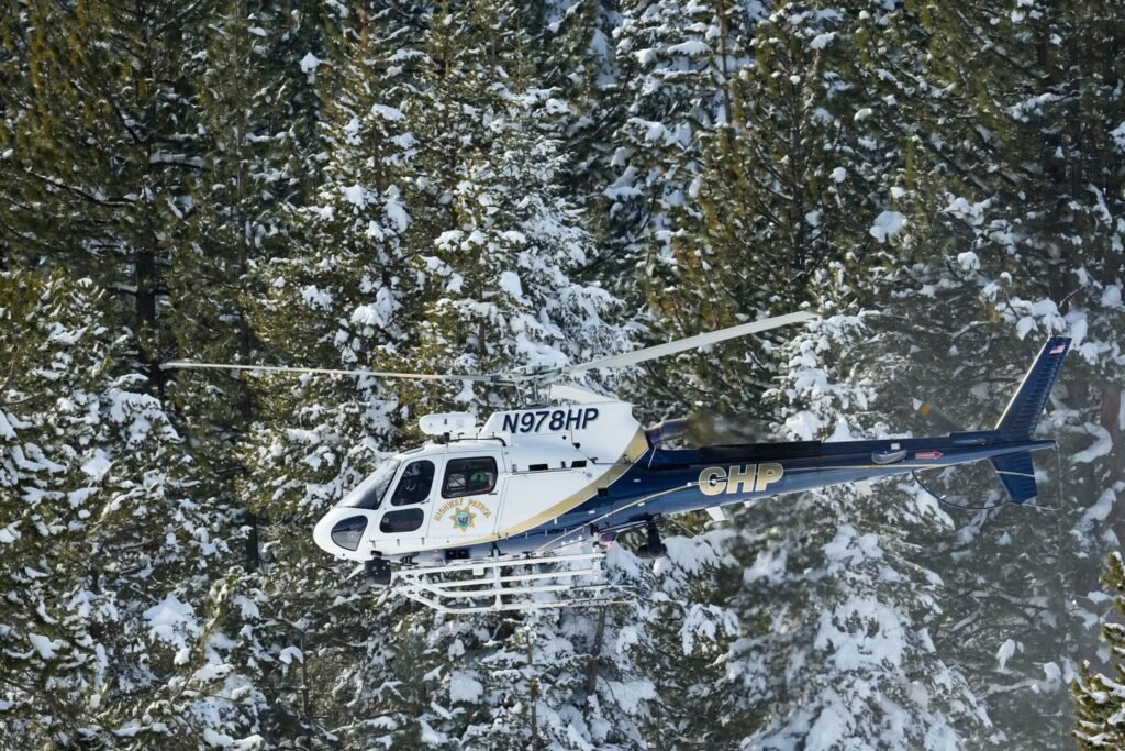 A helicopter heads into California's Sierra Nevada as crews battle brutal conditions to recover 8